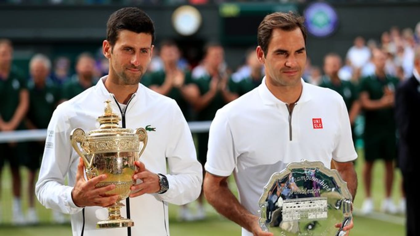 Sichtlich erschöpft stehen Titelverteidiger Novak Djokovic (l) und sein Finalgegner Roger Federer bei der Siegerehrung zusammen.