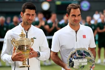 Sichtlich erschöpft stehen Titelverteidiger Novak Djokovic (l) und sein Finalgegner Roger Federer bei der Siegerehrung zusammen.