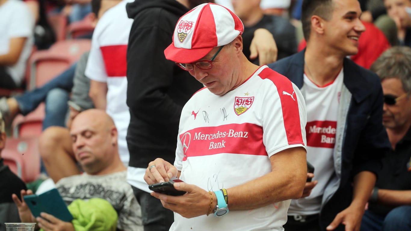 Ein Fan des VfB Stuttgart versucht vergeblich, seine Stimme per Smartphone abzugeben: Wegen technischer Probleme musste die Mitgliederversammlung abgebrochen werden.