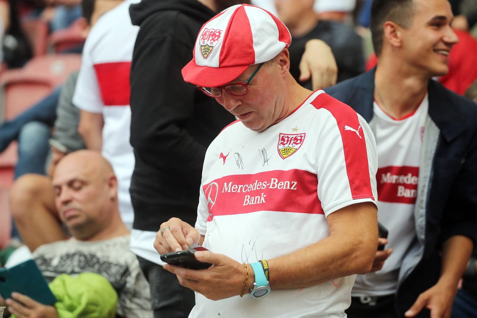 Ein Fan des VfB Stuttgart versucht vergeblich, seine Stimme per Smartphone abzugeben: Wegen technischer Probleme musste die Mitgliederversammlung abgebrochen werden.