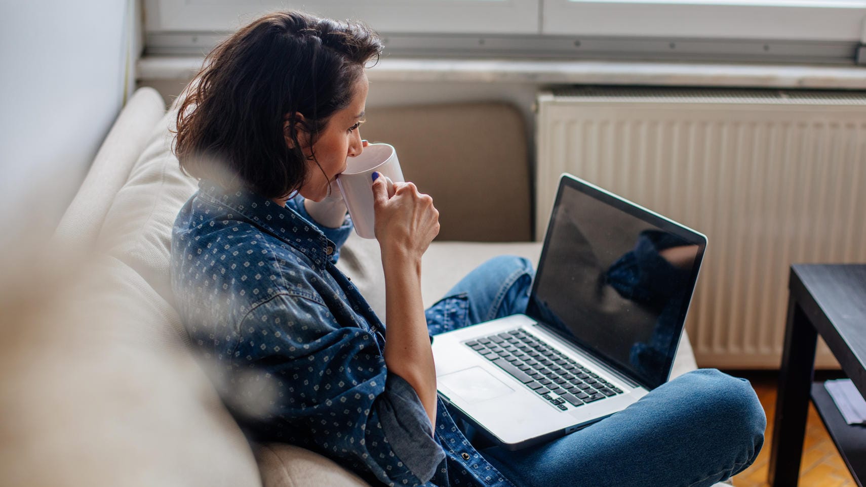 Frau sitzt auf der Couch: 17,3 Millionen Menschen in Deutschland leben in einem Single-Haushalt.