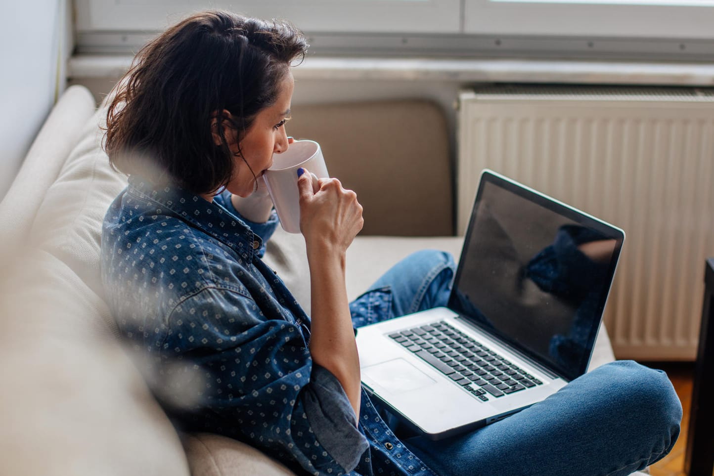 Frau sitzt auf der Couch: 17,3 Millionen Menschen in Deutschland leben in einem Single-Haushalt.