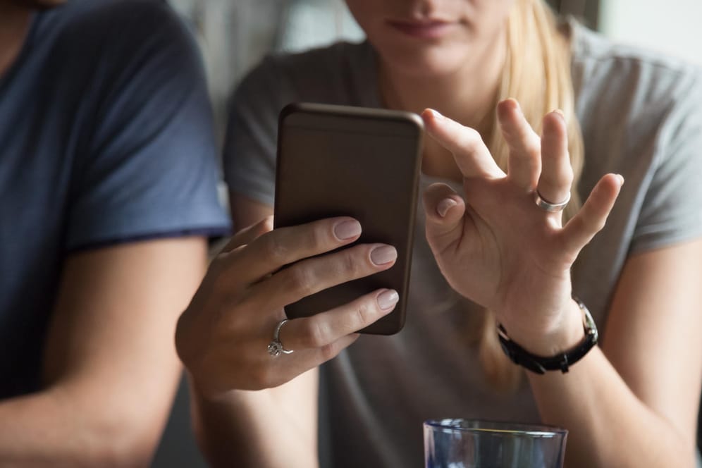 Frau am Smartphone: Weibliche Parship-Mitglieder durchsuchen häufiger das Handy des Partners als männliche.