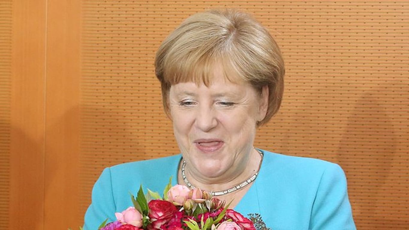 Angela Merkel hält zu Beginn der Kabinettssitzung im Bundeskanzleramt einen Blumenstrauß in den Händen, den sie von den Kabinettskollegen überreicht bekam.