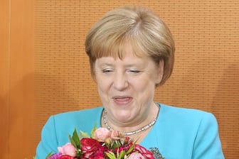 Angela Merkel hält zu Beginn der Kabinettssitzung im Bundeskanzleramt einen Blumenstrauß in den Händen, den sie von den Kabinettskollegen überreicht bekam.