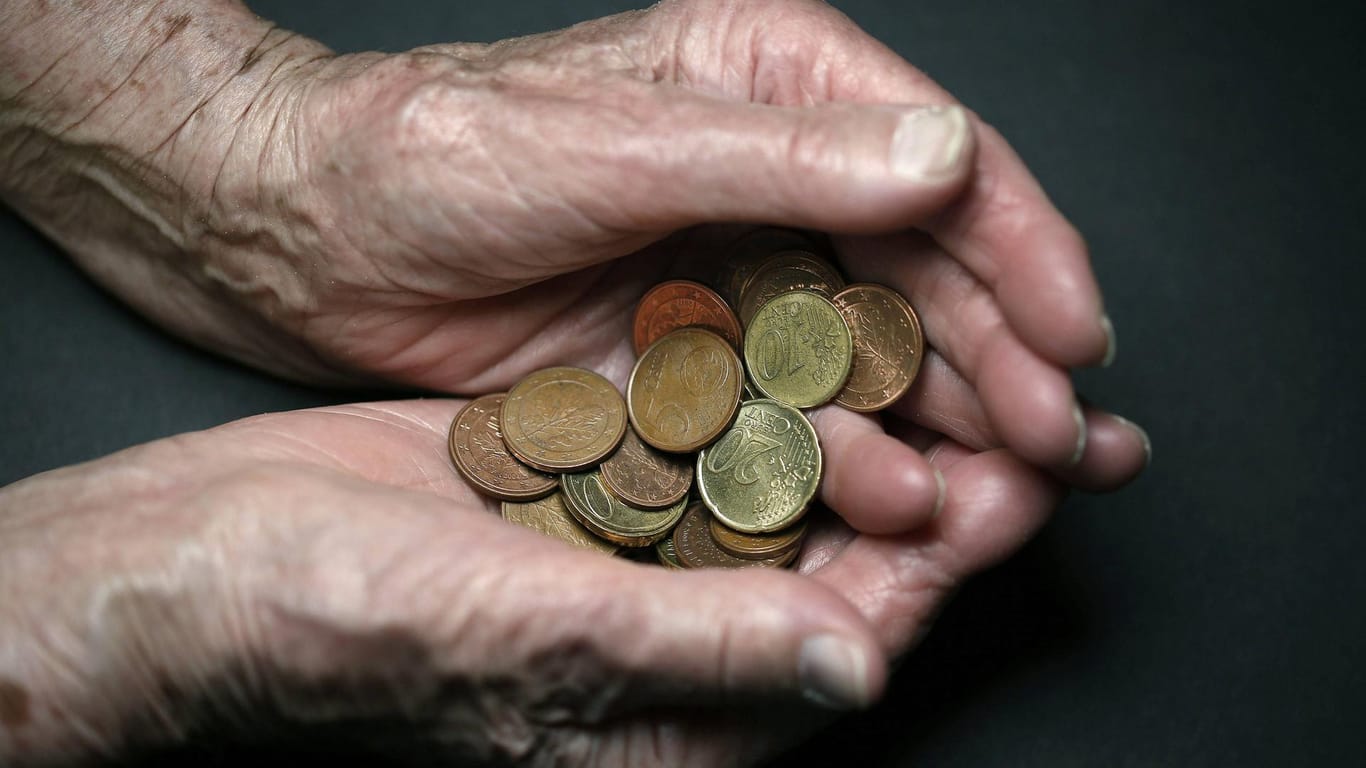 Münzen in den Händen einer alten Frau: Die Auftragslage in der Industrie verschlechtert sich. Das könnten auch Arbeitnehmer zu spüren bekommen.