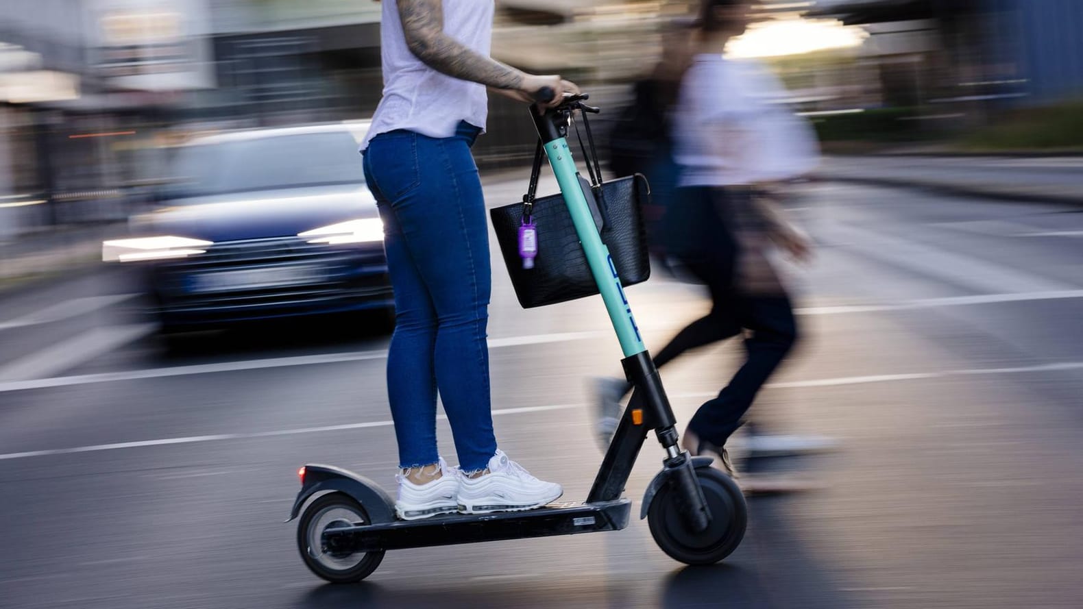 E Scooter Fahrerin in der Kölner Innenstadt: Klappbare E-Tretroller dürfen kostenlos in Bus und Bahn mitgenommen werden. E Scooter Fahrerin in der Kölner Innenstadt: Klappbare E-Tretroller dürfen kostenlos in Bus und Bahn mitgenommen werden.