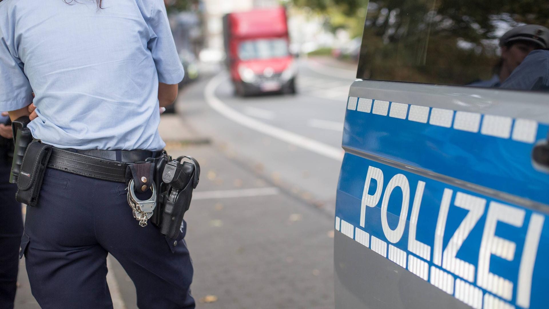 Polizistin neben einem Streifenwagen: Ein Lkw-Fahrer schaute auf sein Handy und fuhr deshalb über Rot. (Symbolbild) Polizistin neben einem Streifenwagen: Ein Lkw-Fahrer schaute auf sein Handy und fuhr deshalb über Rot. (Symbolbild)