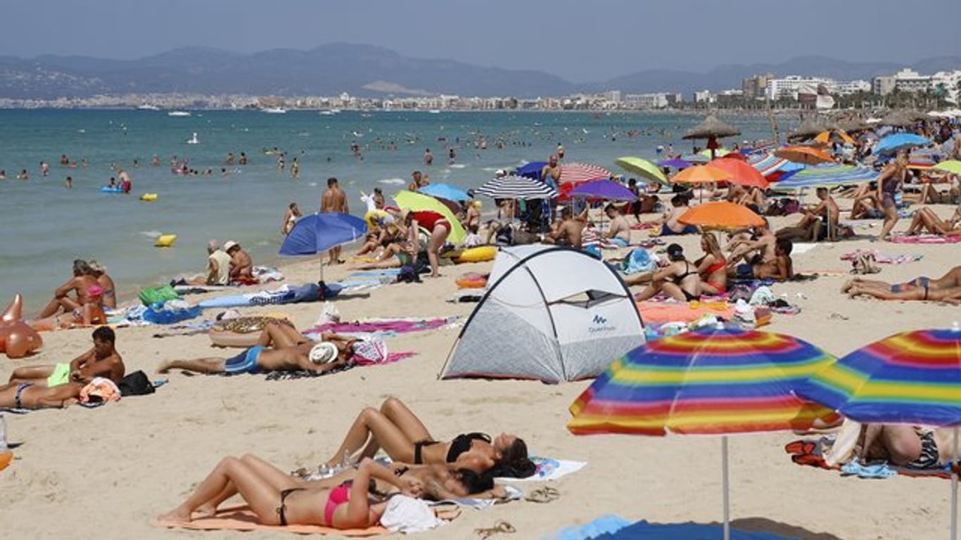 Hier darf weiter gequalmt werden: Touristen sonnen sich am Strand von El Arenal auf Mallorca.