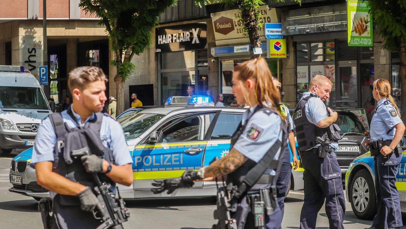 Polizisten stehen in Dortmund vor einem Friseursalon
