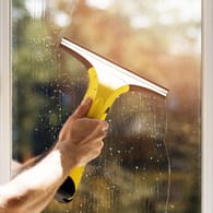 Ein Akku-Fenstersauger im Einsatz: Mit den kleinen Geräten sparen Sie Kraft und Zeit beim Fensterputzen.