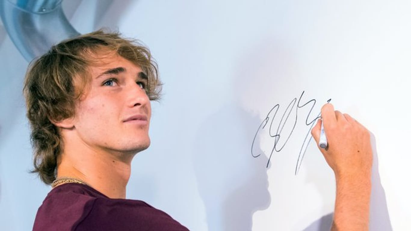 Alexander Zverev signiert während der Pressekonferenz der European Open in Hamburg eine Wand.