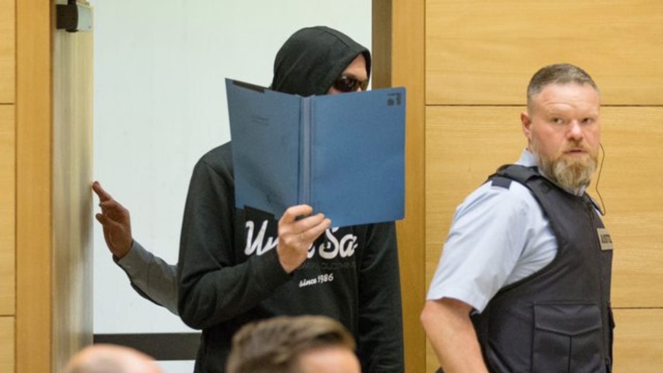 Einer der beiden Angeklagte betritt den Sitzungssaal im Landgericht Bielefeld.
