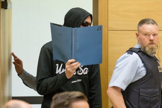 Einer der beiden Angeklagte betritt den Sitzungssaal im Landgericht Bielefeld.