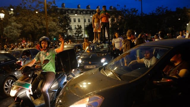 Fans der algerischen Nationalmannschaft feiern auf der Champs-Elysées. Fans der algerischen Nationalmannschaft feiern auf der Champs-Elysées.