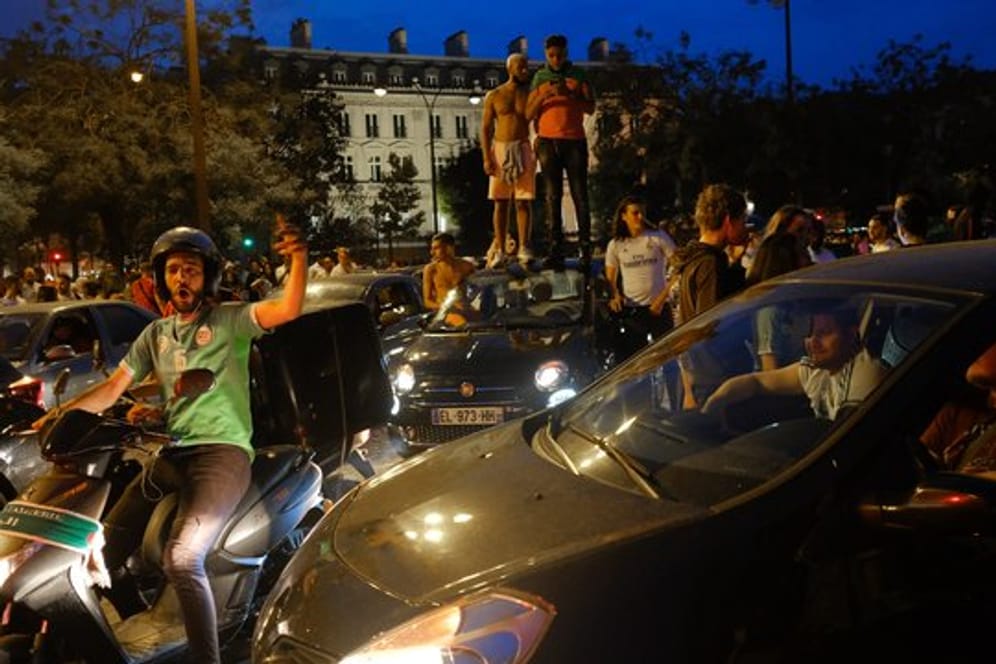 Fans der algerischen Nationalmannschaft feiern auf der Champs-Elysées.
