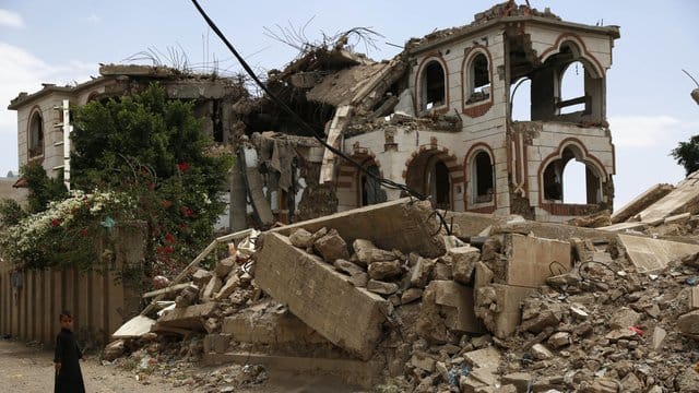 Ein Kind steht vor einem zerstörten Haus in der jemenitischen Hauptstadt Sanaa.