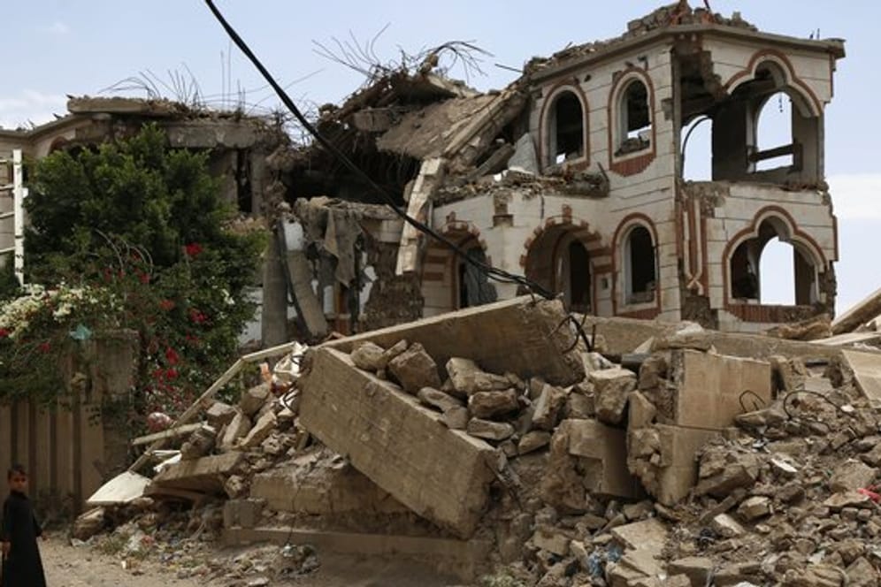 Ein Kind steht vor einem zerstörten Haus in der jemenitischen Hauptstadt Sanaa.