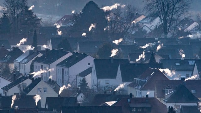 Schornsteine rauchen auf den Dächern der Häuser.