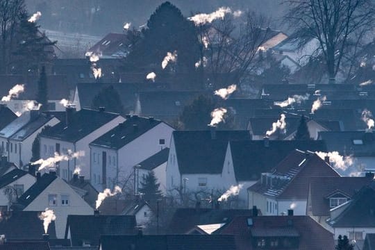 Schornsteine rauchen auf den Dächern der Häuser.