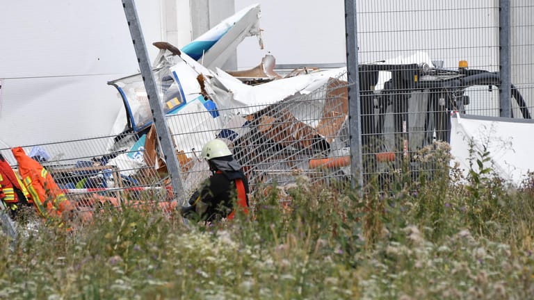 An der Fassade eines Bauhaus-Baumarktes liegen die Trümmer eines Kleinflugzeugs, das dort abgestürzt ist. Nach ersten Erkenntnissen der Polizei hat es bei dem Absturz drei Tote gegeben.