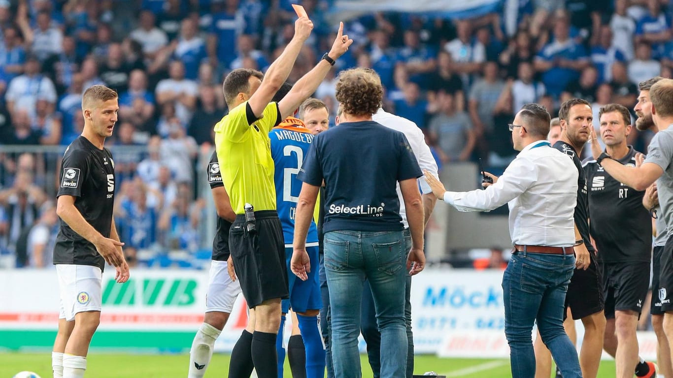 Voll gefordert: Schiri Zwayer zeigt Magdeburgs Co-Trainer Bankert die Rote Karte.