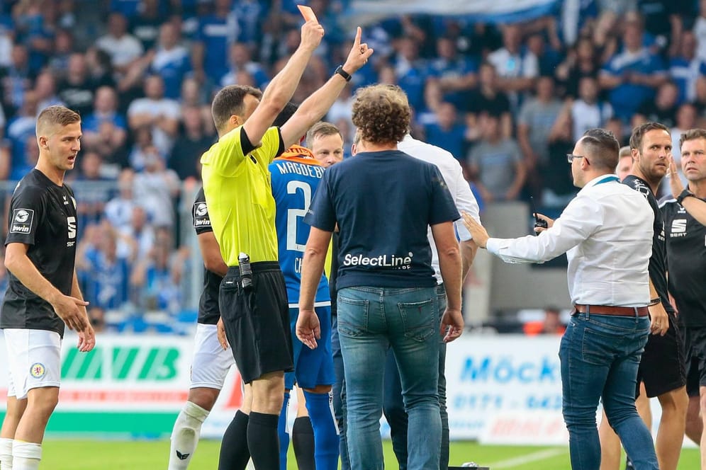 Voll gefordert: Schiri Zwayer zeigt Magdeburgs Co-Trainer Bankert die Rote Karte.