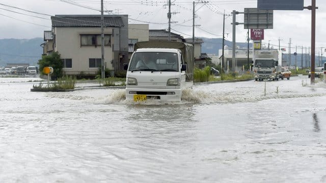 Eine Straße in Tachiarai in der Präfektur Fukuoka im Südwesten Japans steht nach starken Regenfälle unter Wasser. Eine Straße in Tachiarai in der Präfektur Fukuoka im Südwesten Japans steht nach starken Regenfälle unter Wasser.