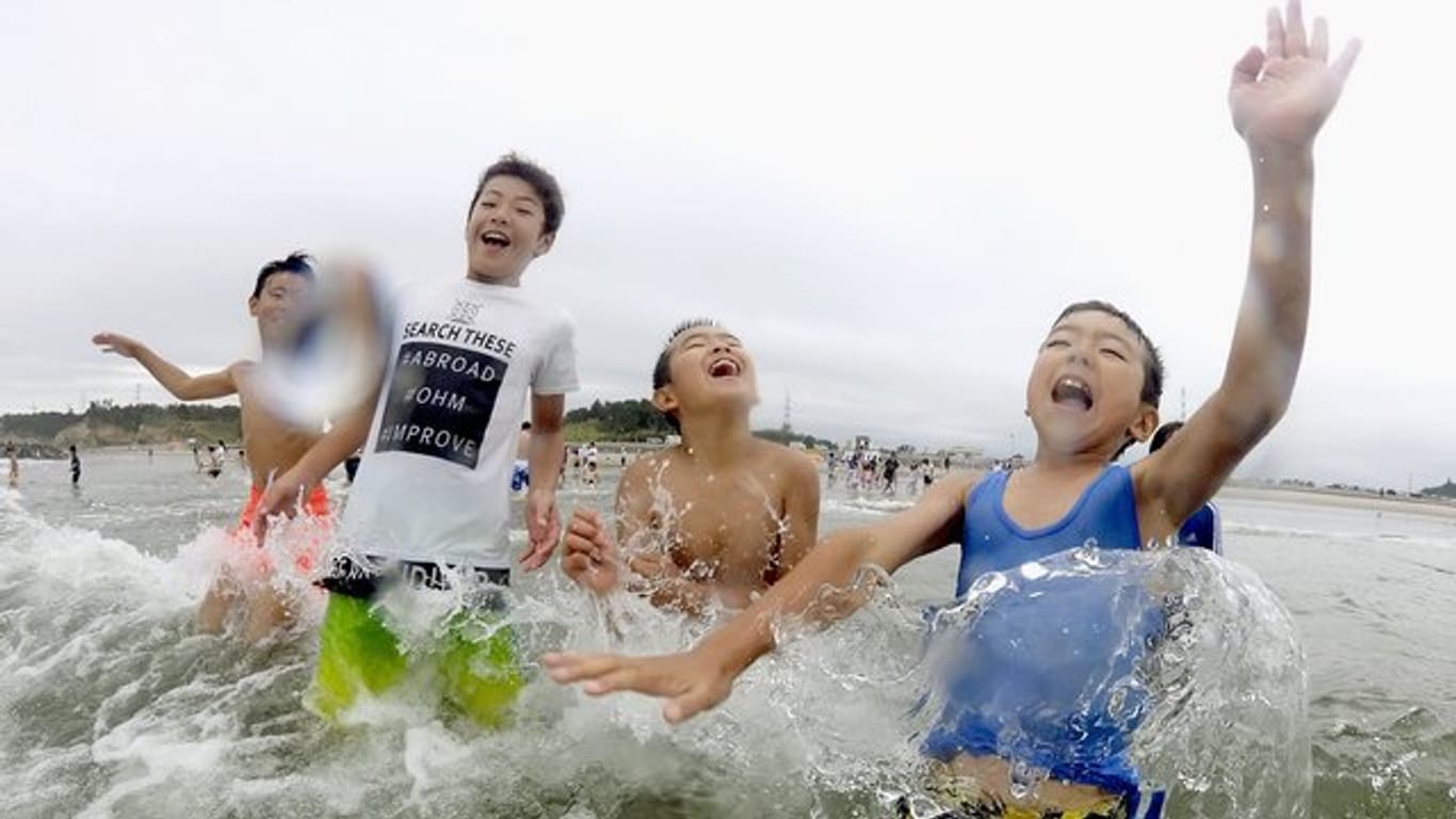 Kinder spielen im Wasser: Nach der Nuklearkatastrophe von Fukushima wurde der Strand zum ersten Mal wieder für Besucher zugelassen.