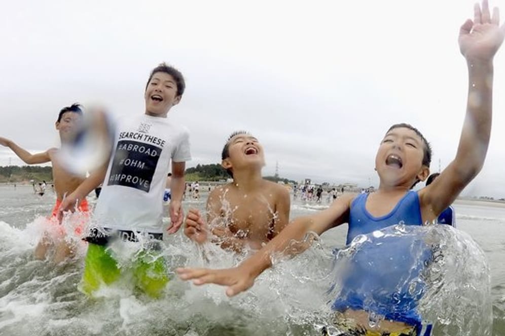 Kinder spielen im Wasser: Nach der Nuklearkatastrophe von Fukushima wurde der Strand zum ersten Mal wieder für Besucher zugelassen.