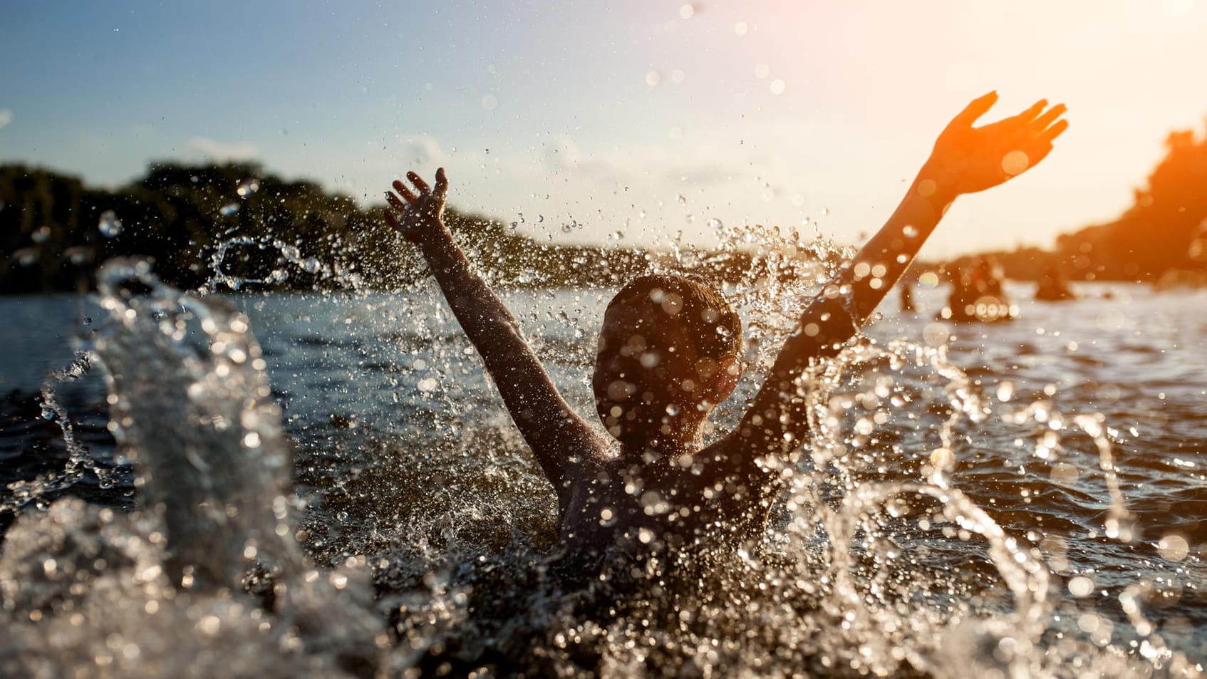 Plantschen im See: Ein überhitzter Körper sollte langsam an die kühlere Wassertemperatur gewöhnt werden.