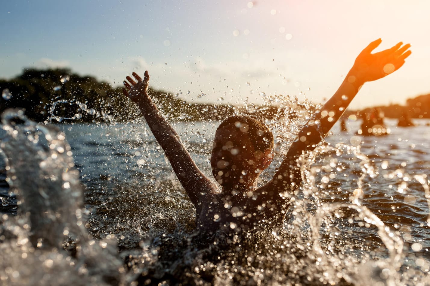 Plantschen im See: Ein überhitzter Körper sollte langsam an die kühlere Wassertemperatur gewöhnt werden.