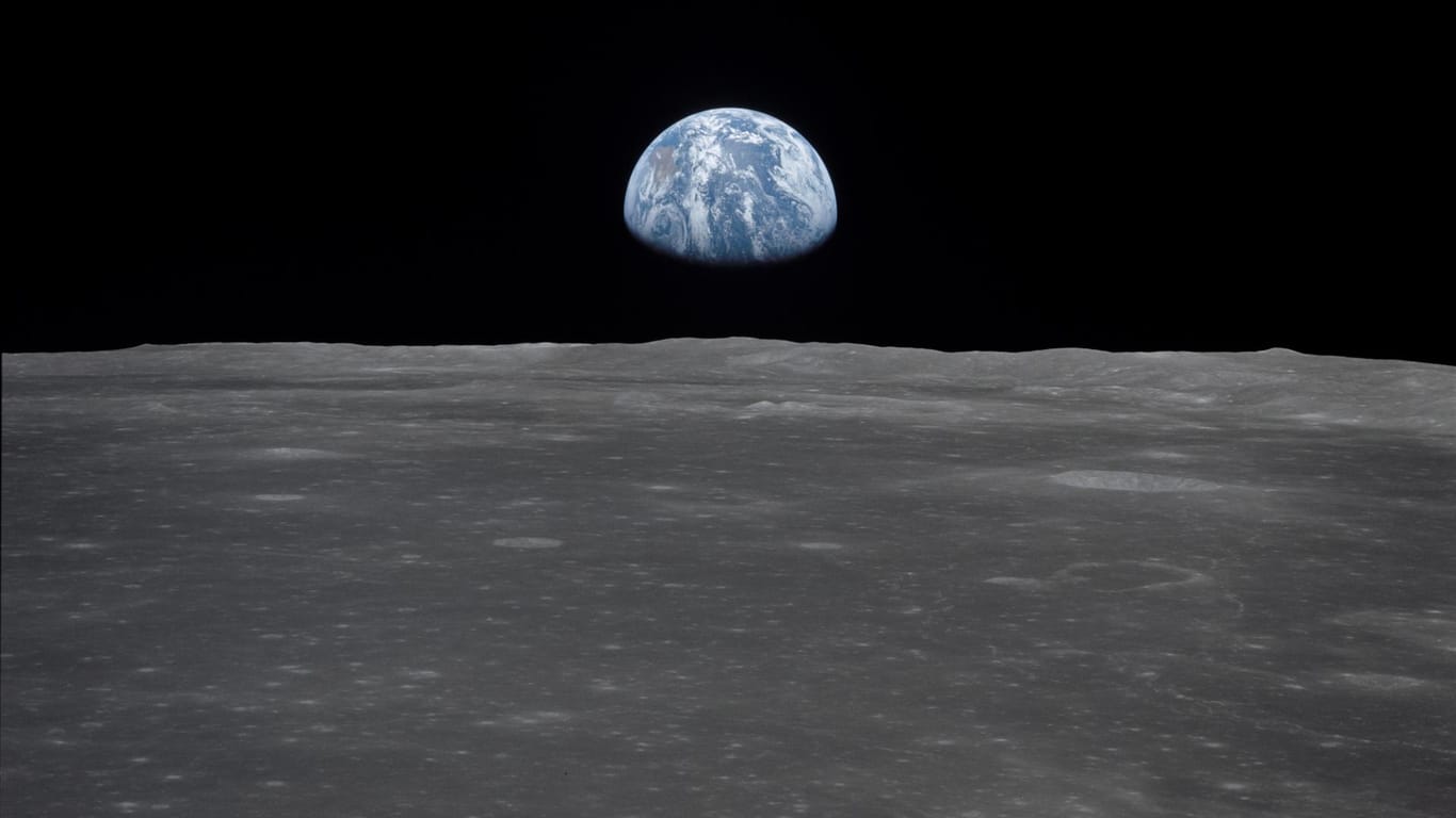 Armstrong und Aldrin erkundeten den Mond zu Fuß, Collins blieb in der Mondfähre zurück – und nahm dieses Bild auf. Es zeigt, wie die Erde über dem Horizont des Mondes aufsteigt.