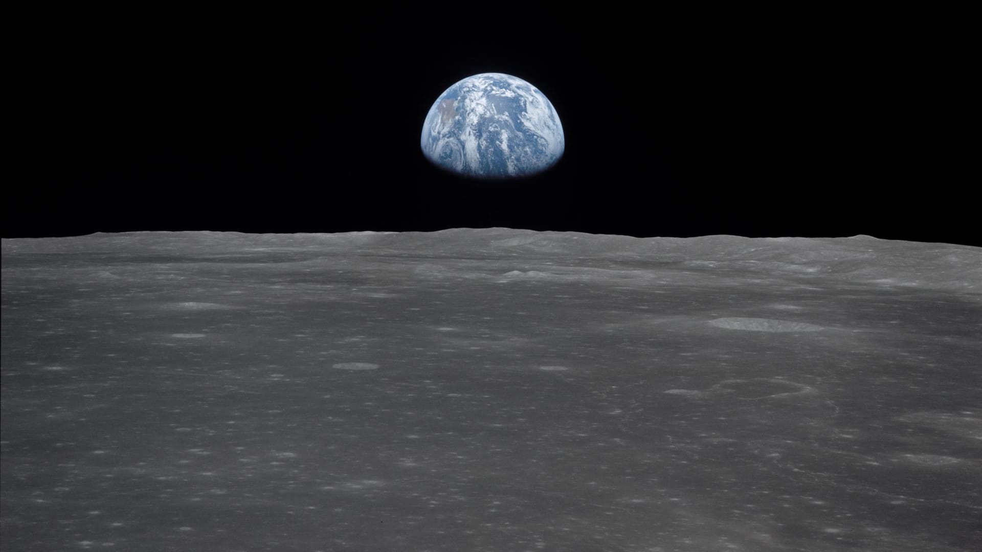 Armstrong und Aldrin erkundeten den Mond zu Fuß, Collins blieb in der Mondfähre zurück – und nahm dieses Bild auf. Es zeigt, wie die Erde über dem Horizont des Mondes aufsteigt.