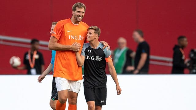 Dirk Nowitzki (l) und Mick Schumacher klatschen sich während der Partie ab. Dirk Nowitzki (l) und Mick Schumacher klatschen sich während der Partie ab.