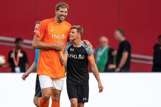 Dirk Nowitzki (l) und Mick Schumacher klatschen sich während der Partie ab.