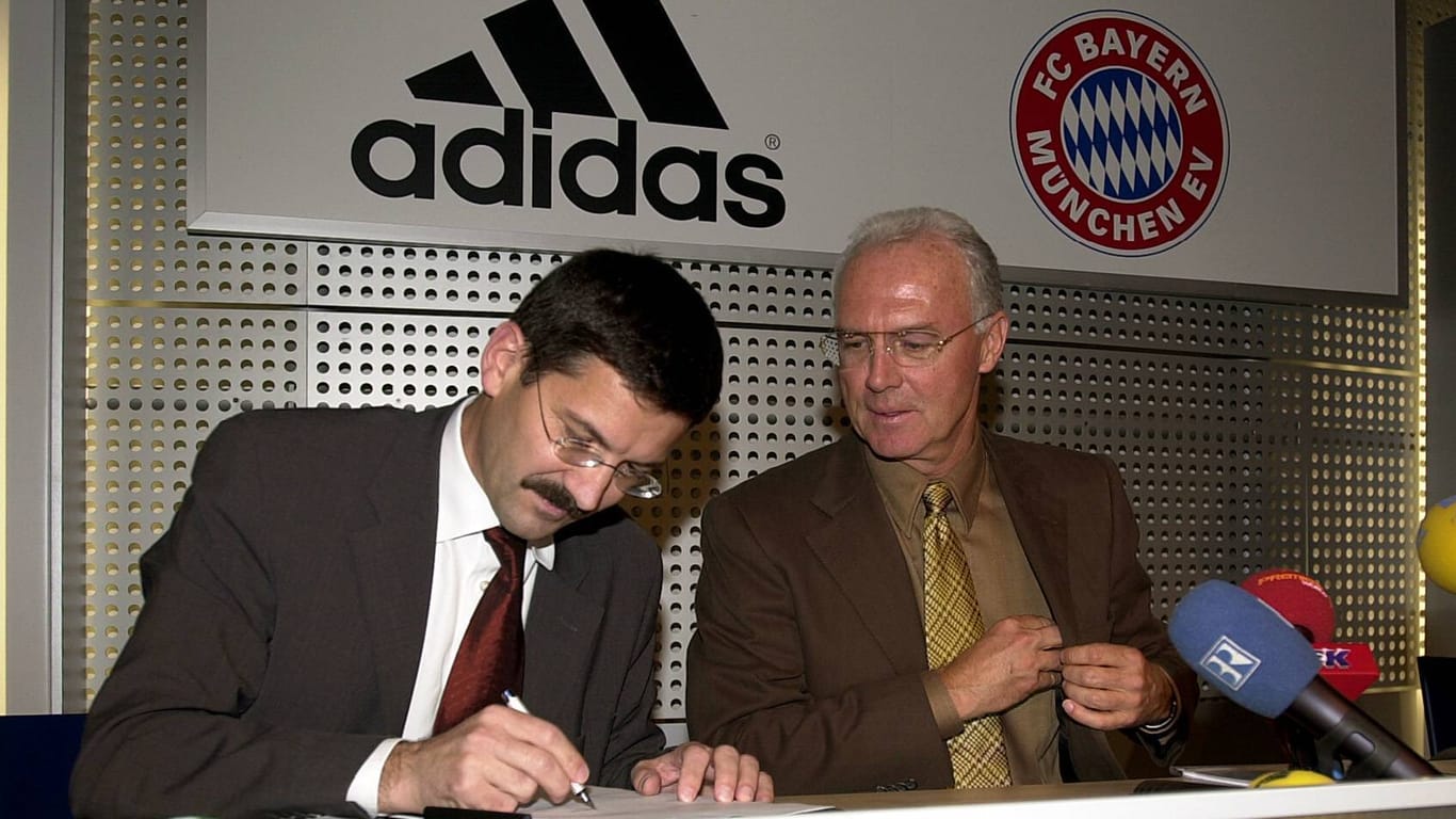 2002: Der damalige Adidas-Chef Hainer (li.) und Bayern-Präsident Franz Beckenbauer unterzeichnen die zehnprozentige Beteilung des Unternehmens am Rekordmeister.