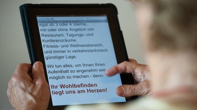 Eine Seniorin bedient einen Tablet-Computer.