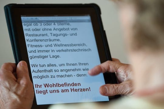 Eine Seniorin bedient einen Tablet-Computer.