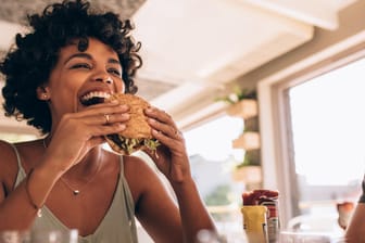 Eine Frau isst einen Burger: Kulinarisch kommt in Hagen fast jeder auf seine Kosten.