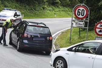 Hier geht's nicht weiter: Ein Polizist hält Autos auf einer Straße bei Innsbruck an.