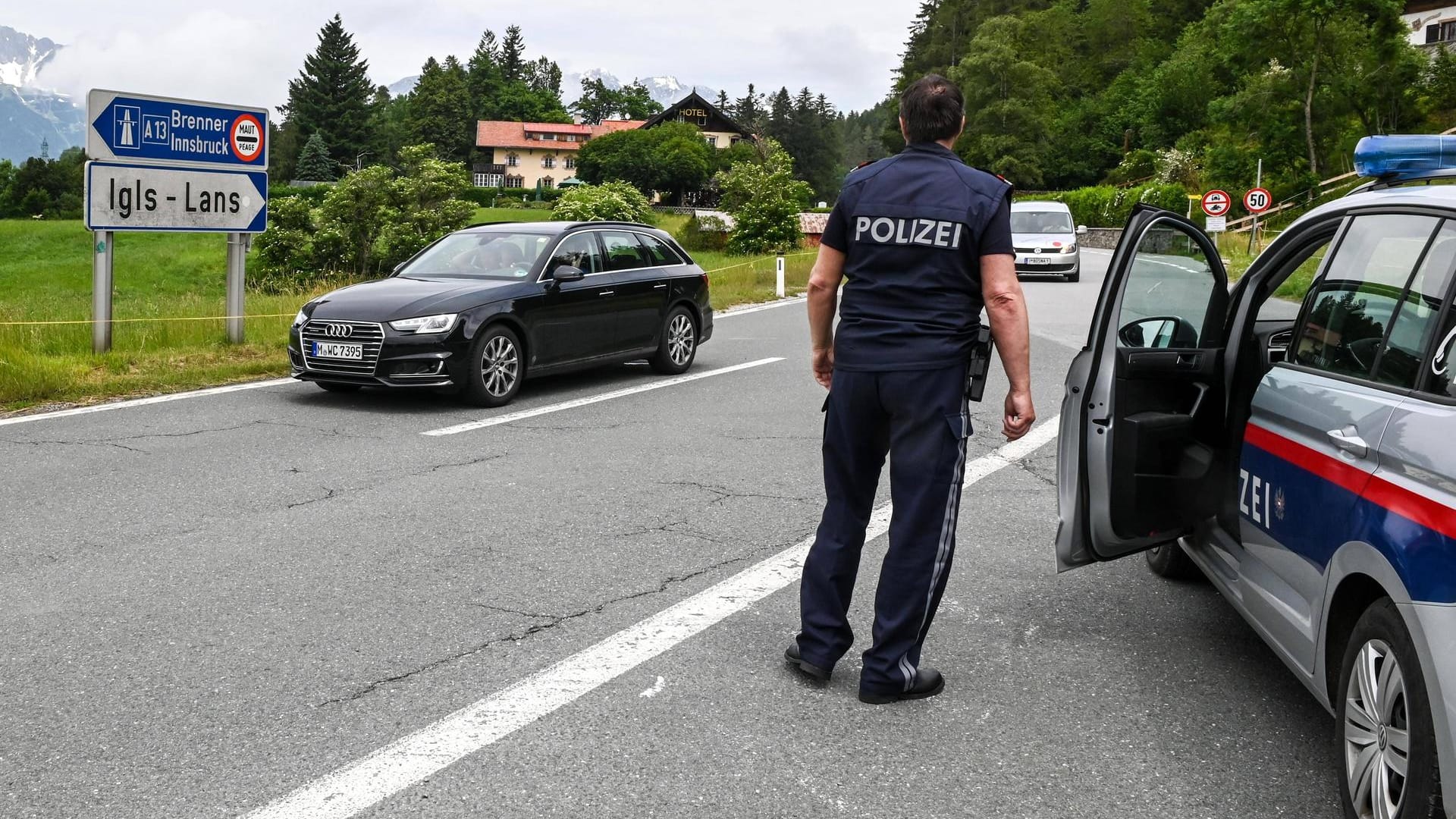 Österreichische Polizisten kontrollieren an einer Autobahnabfahrt deutsche Autofahrer: Im Raum Innsbruck sind Ausweichrouten am Wochenende für Urlauber gesperrt.