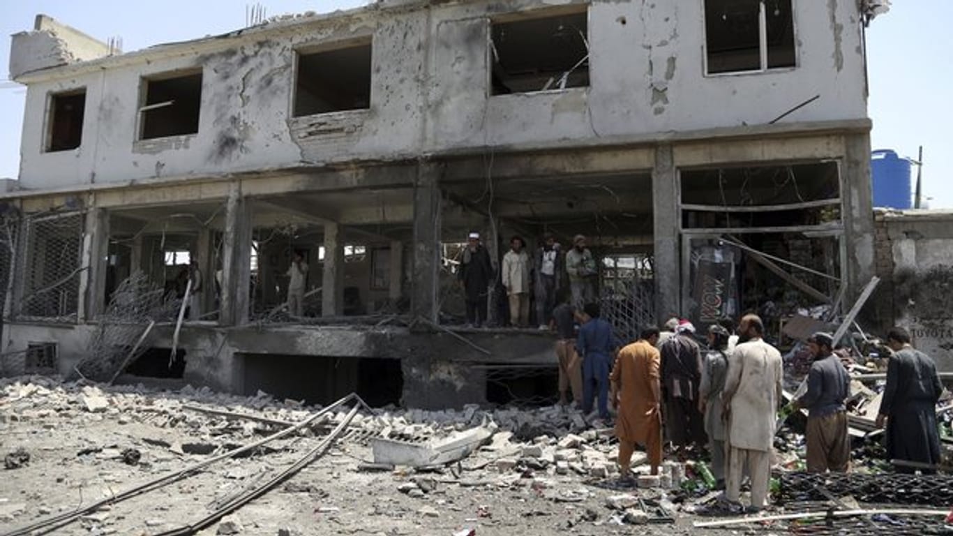 Afghanische Männer suchen nach dem Anschlag nach persönlichen Gegenständen in ihren Läden.