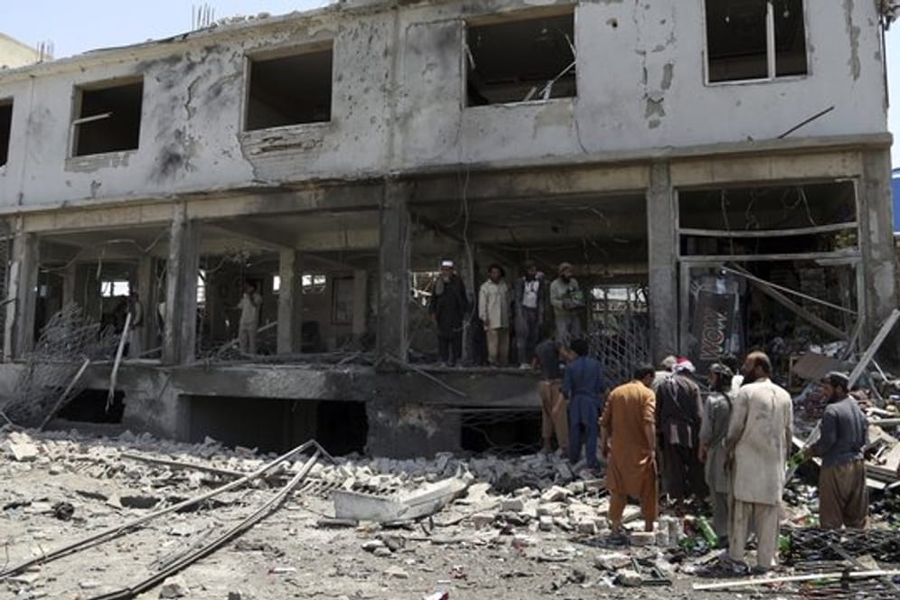 Afghanische Männer suchen nach dem Anschlag nach persönlichen Gegenständen in ihren Läden.
