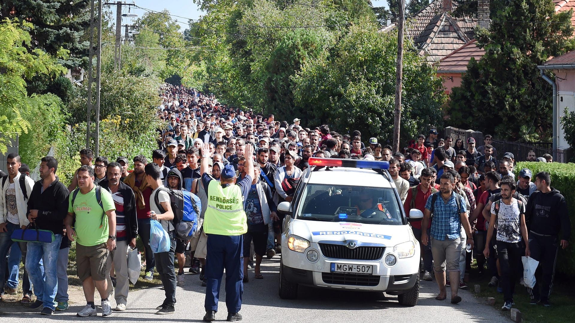 Ungarische Polizisten begleiten einen Flüchtlingszug zur Grenze nach Österreich: Ungarn muss sich vor dem EuGH verantworten.