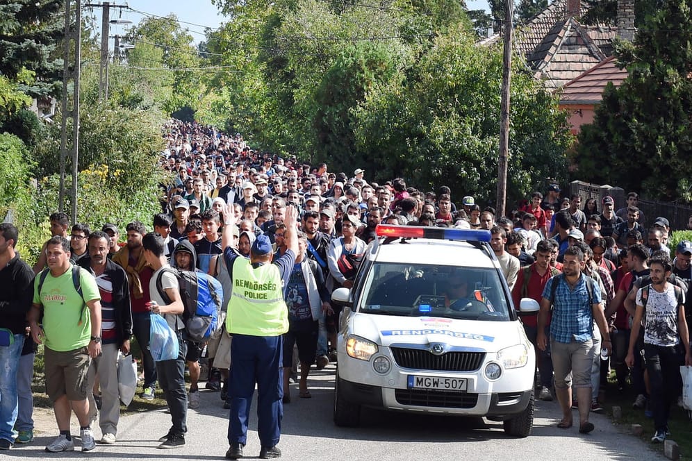 Ungarische Polizisten begleiten einen Flüchtlingszug zur Grenze nach Österreich: Ungarn muss sich vor dem EuGH verantworten.
