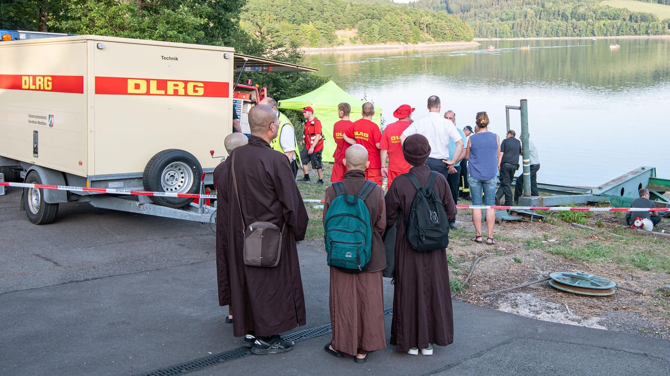 Mönche des buddhistischen Klosters aus Waldbröl stehen am Biggesee: Ihr Mitbruder ging beim Schwimmen unter und verschwand.