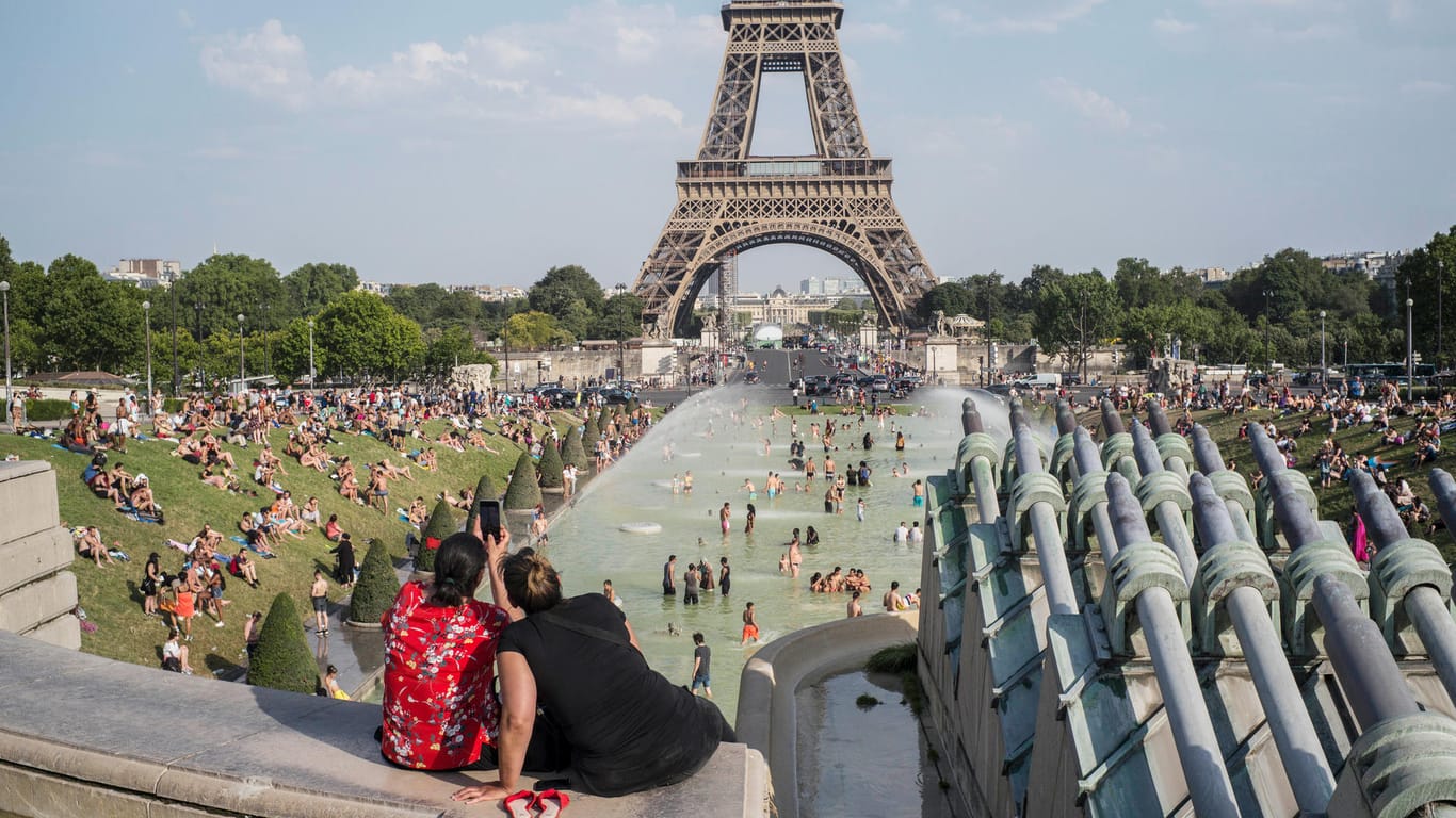 Frankreich, Paris: Menschen erfrischen sich in einem Brunnen am Place du Trocadero vor dem Eiffelturm.