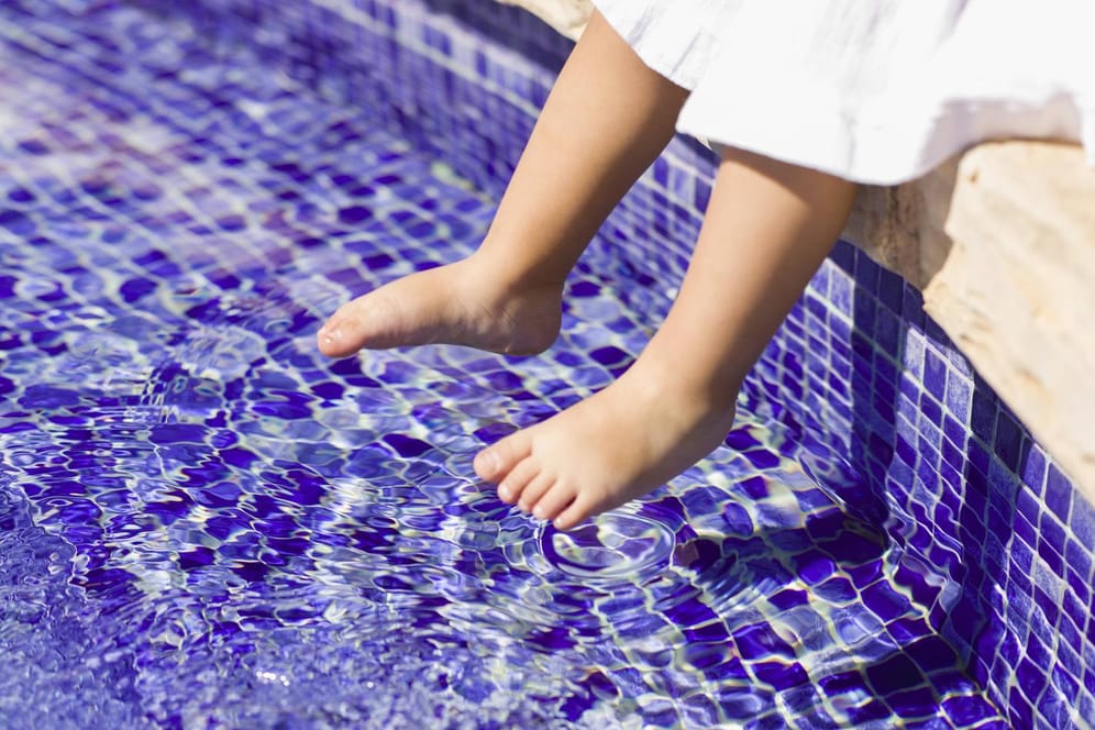 Kinderfüße im Wasser: Eltern sollten Ihre Kinder stets im Blick haben, wenn sich diese in der Nähe von Wasser aufhalten.