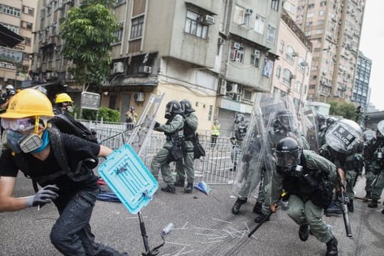 Ein Demonstrant flieht vor Polizisten im Bezirk Yuen Long .